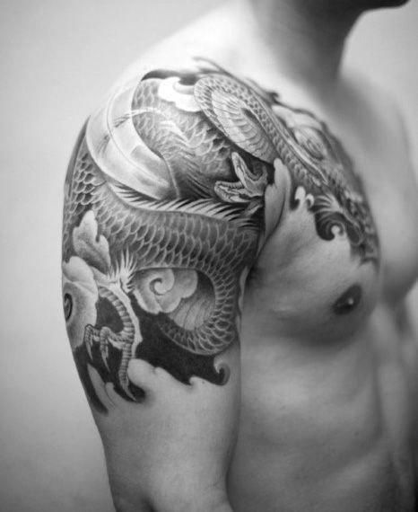 Joli tattoo qui s'étend sur l'épaule et la partie haute du bras