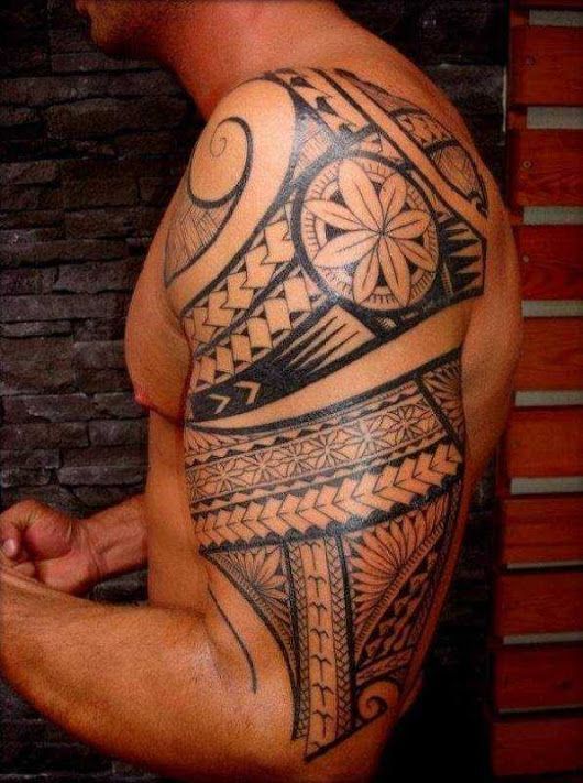 Un tattoo qui s'étend au niveau du bras et l'épaule
