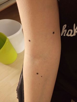 Des tattoos un peu partout, étoiles en encre noir