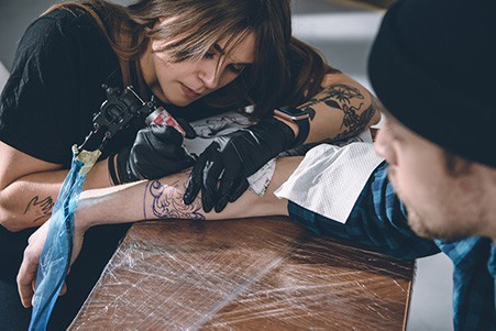 tatoueur donnant un tatouage