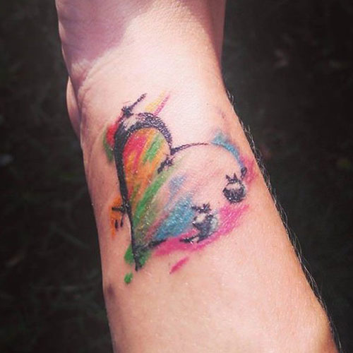 Tatouage de point-virgule coeur coloré sur l'avant-bras du poignet