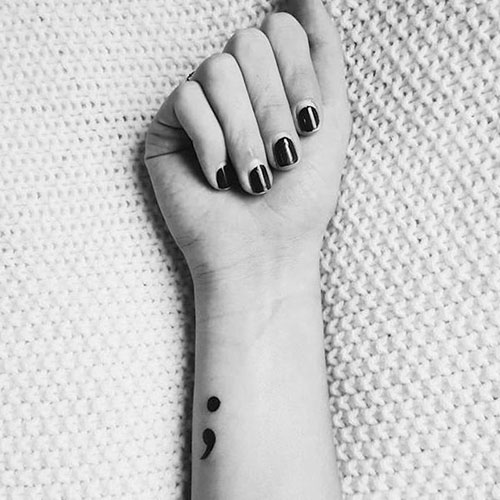 Petit tatouage simple de point-virgule noir sur le poignet