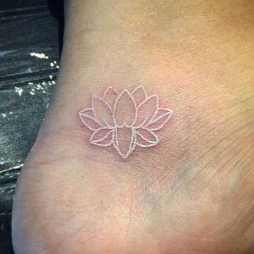 Tatouage fleur de lotus à l'encre blanche